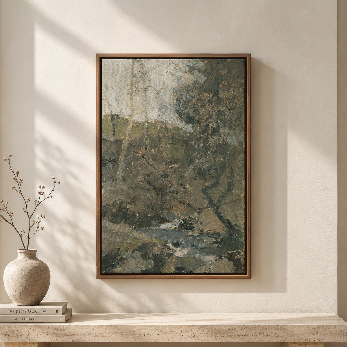Living Water in the Autumn Ravine framed wall art above a travertine bench with a vase and books