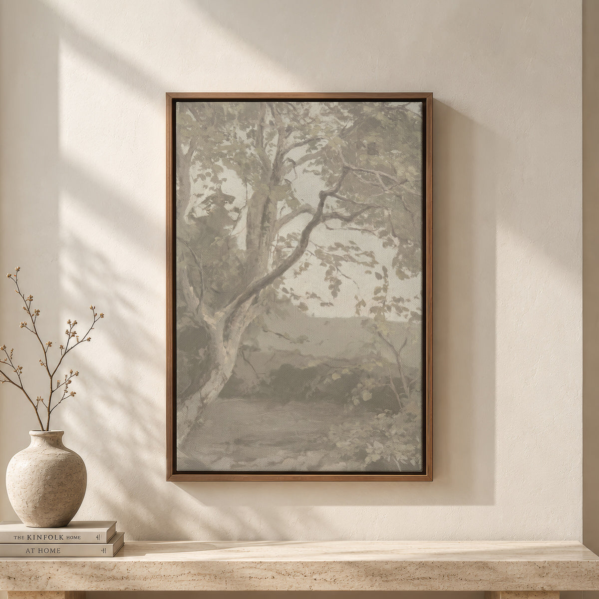 Greige Tree in Quiet Light framed wall art above a travertine bench with a vase and books