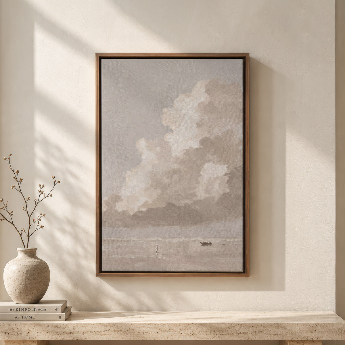 One Cloud Over the Water framed wall art above a travertine bench with a vase and books