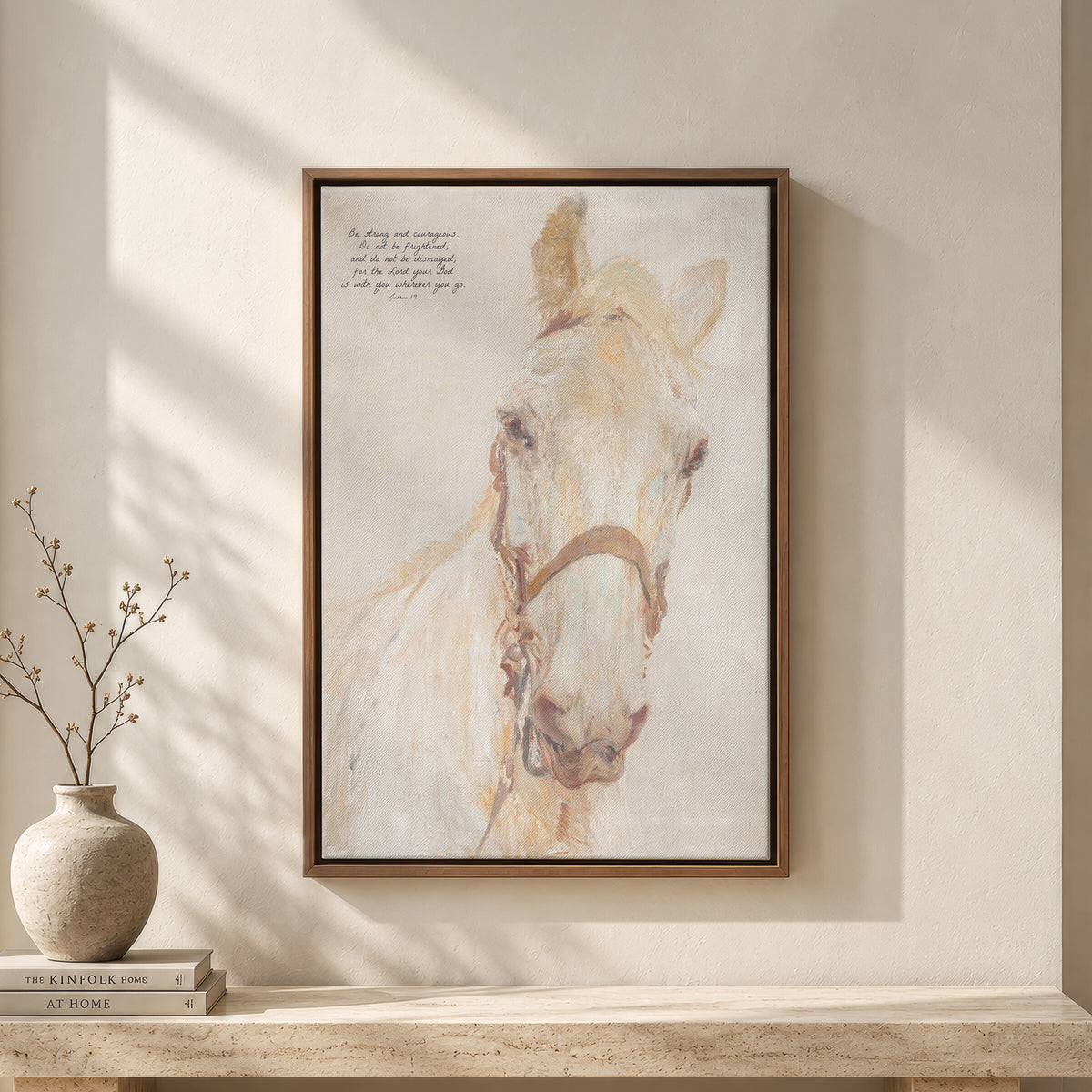 Be Strong, White Horse framed wall art above a travertine bench with a vase and books